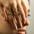 Mujer modelando dos anillos abierto, ajustable, de dos tiras con zirconia blancas. A prueba de agua de acero inoxidable con chapa de oro.